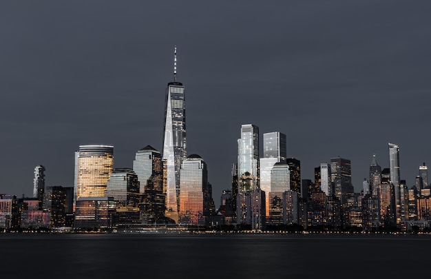 Foto gratuita incredibile colpo degli alti grattacieli moderni dello skyline della città di notte
