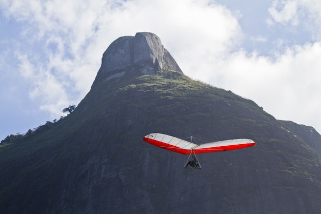 Free photo amazing shot of human flying on a hang glider