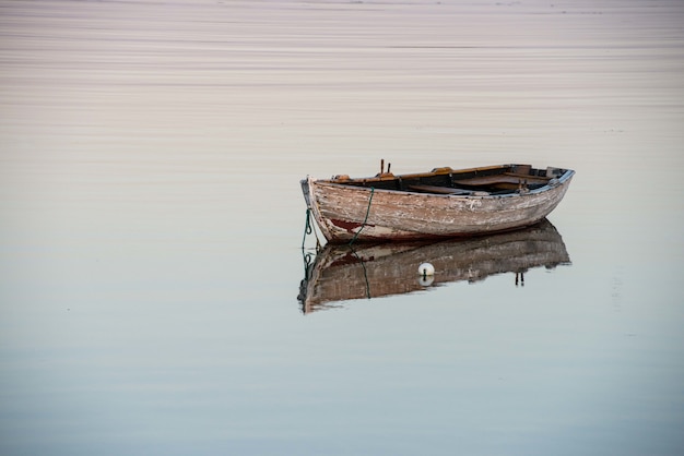 Удивительный снимок старой деревянной лодки на отражающем озере