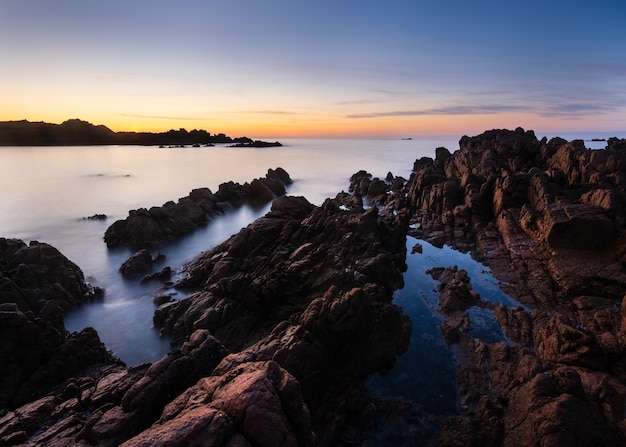 Foto gratuita incredibile scatto di una spiaggia rocciosa al tramonto