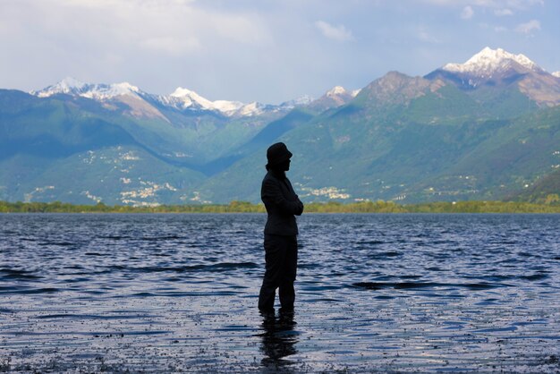 Amazing view of a female silhouette standing in the middle of a lake