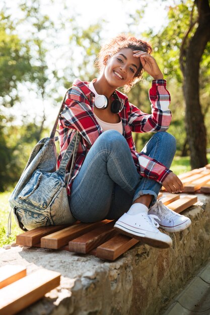 Amazing young african woman sitting outdoors in park