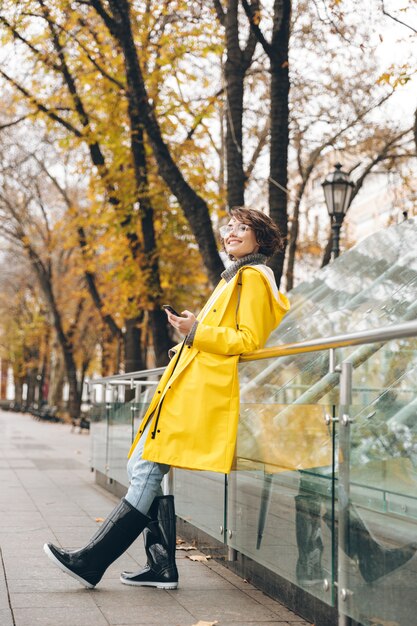 Amazing young woman dressed in raincoat