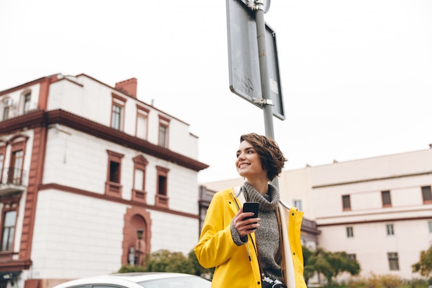 Amazing young woman dressed in raincoat