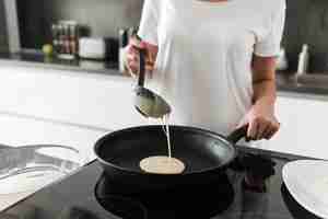 Foto gratuita giovane donna stupefacente che sta alla cucina nella casa