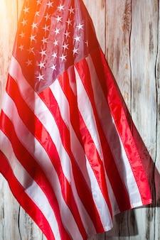 Американский флаг на деревянных фоне. флаг сша. баннер в солнечном свете. земля возможностей.