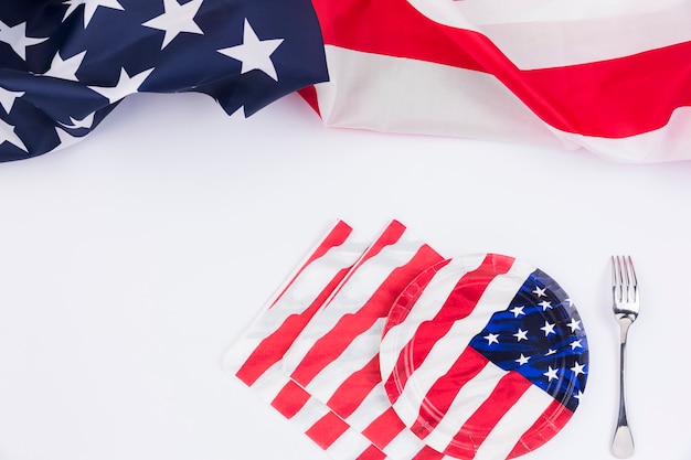 Американский флаг тарелки вилка и баннер на белой поверхности