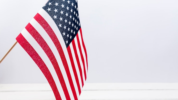 無料Photo スタジオで白い壁に手を振るアメリカの国旗
