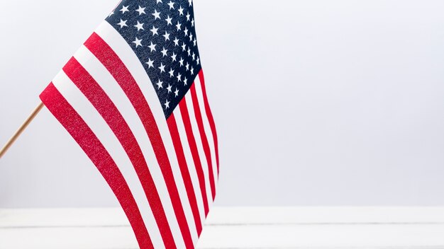 American flag waving against white wall in studio