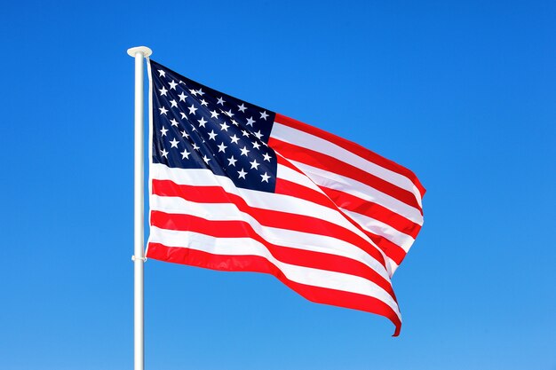 American flag waving in blue sky