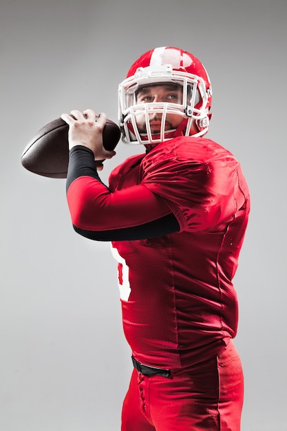 American football player posing with ball on white