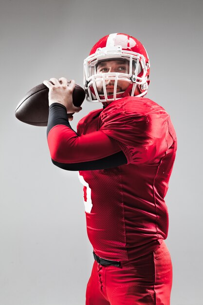 American football player posing with ball on white