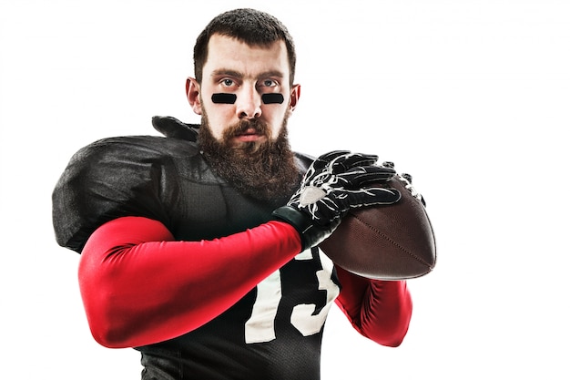 American football player posing with ball on white