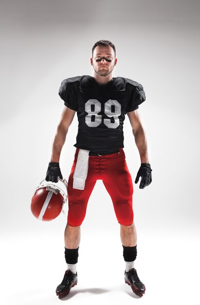 American football player posing with ball on white