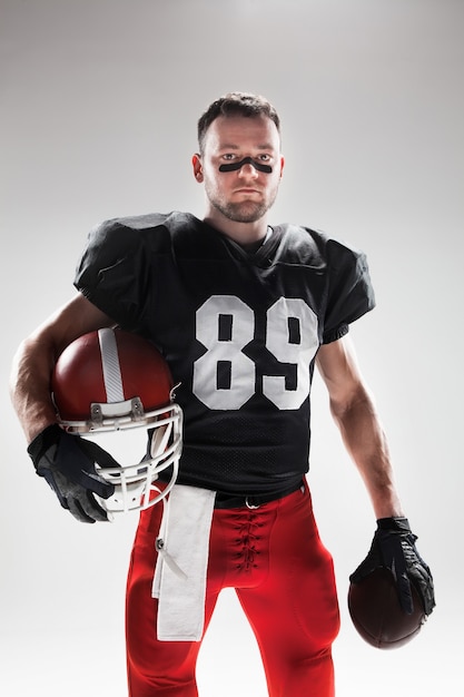 American football player posing with ball on white background | American football  players, American football, Football players