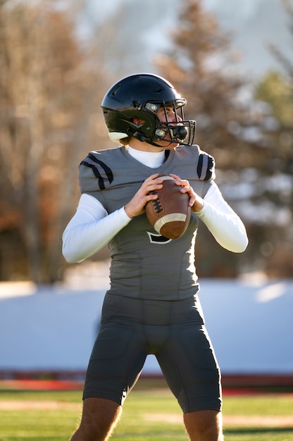 Foto gratuita giocatore di football americano in allenamento uniforme sul campo