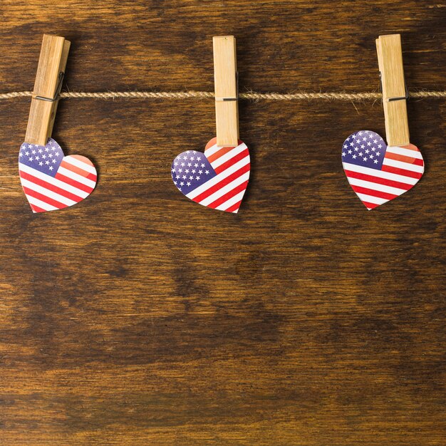 American heart shape with clothespins hanging on clothesline over the wooden desk