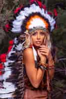 Бесплатное фото Девушка американских индейцев в национальном костюме в головном уборе из перьев птиц