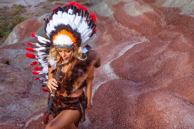 American Indian girl in native costume headdress made of feathers of birds