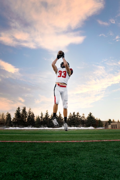 Foto gratuita giocatore di football americano maschio in uniforme sul campo