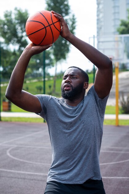 American man throwing a ball to hoop 