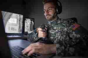 Foto gratuita soldato americano nel centro di controllo del quartier generale che inizializza l'attacco di un drone