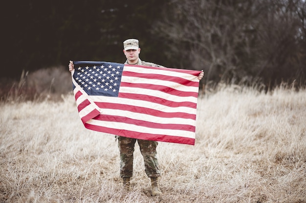 アメリカの国旗を持っているアメリカの兵士