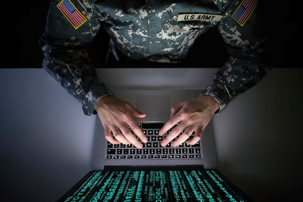 Foto gratuita soldato americano in uniforme militare che impedisce attacchi informatici nel centro di intelligence militare