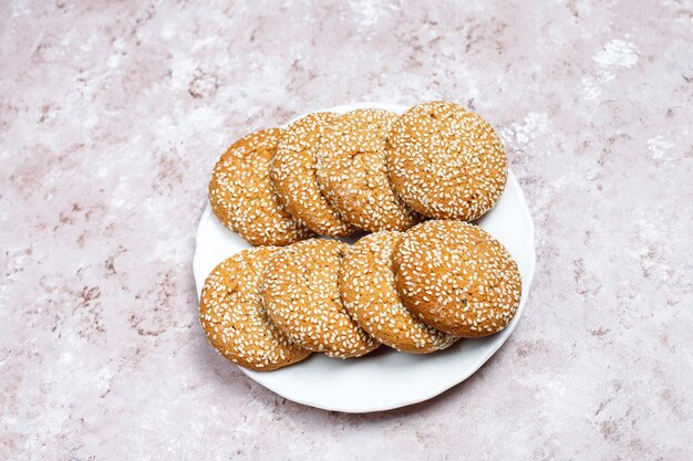 American style sesame seed cookies on light concrete background.