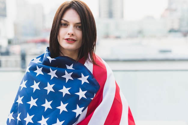 American woman wrapped in flag on Independence Day 