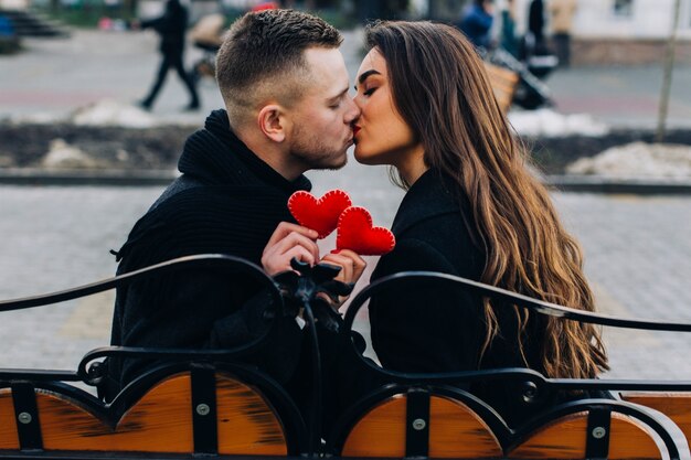 Любовная пара целует на скамейке