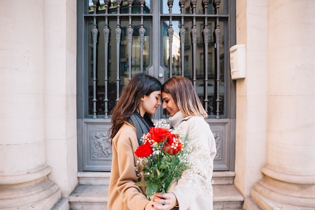 Amorous girlfriends posing with flowers