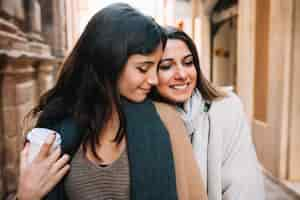 Free photo amorous girlfriends walking on street