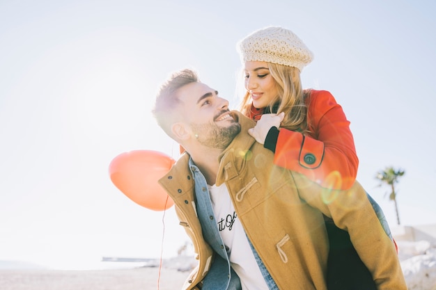 Foto gratuita uomo amoroso che porta la ragazza sul retro