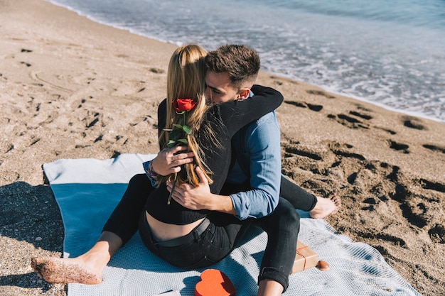 Amorous people embracing gently on beach