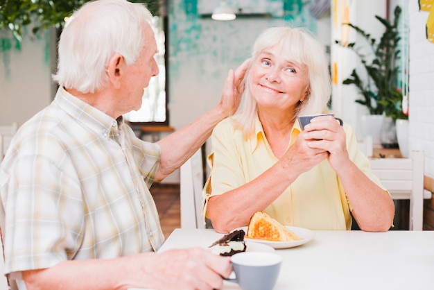 Amorous senior couple sitting in cafe