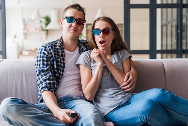 Free photo amused couple watching film and bonding on sofa