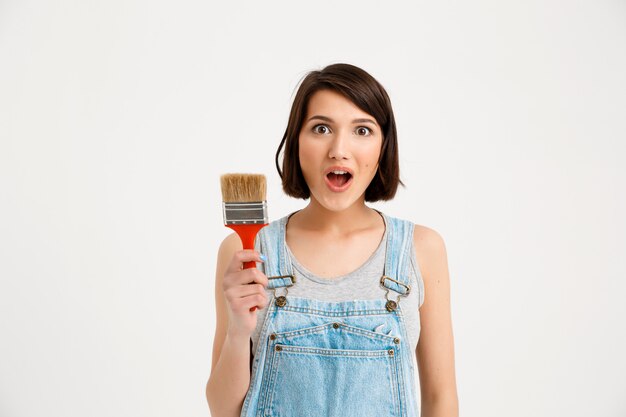 Amused creative woman with painting brush