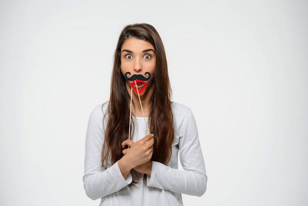 Amused cute woman with fake lips and moustache