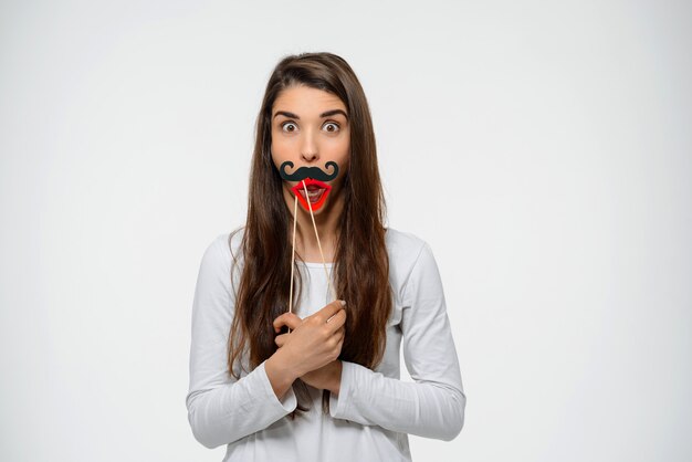 Amused cute woman with fake lips and moustache