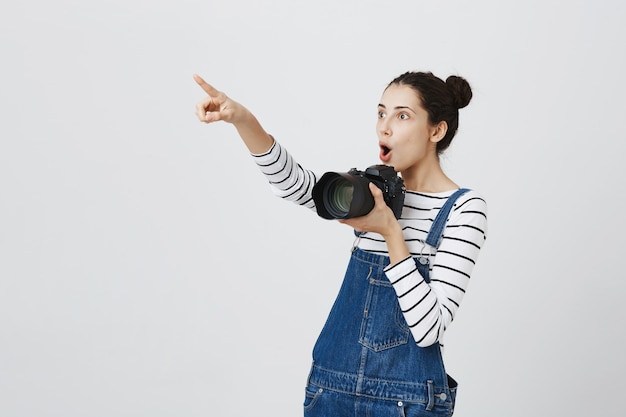 左上隅を指してカメラを持って、写真を撮って、面白がってかわいい女の子