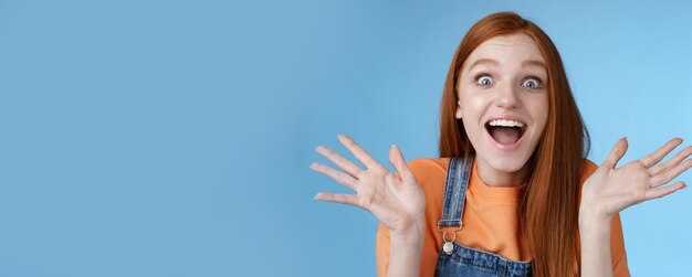 Free photo amused speechless surprised astonished redhead girl hear exciting positive news smiling gladly wide