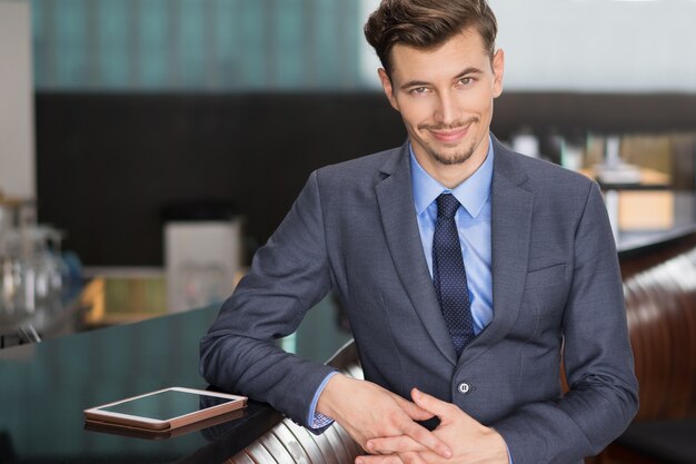 Amusing Young Businessman Standing at Cafe Counter