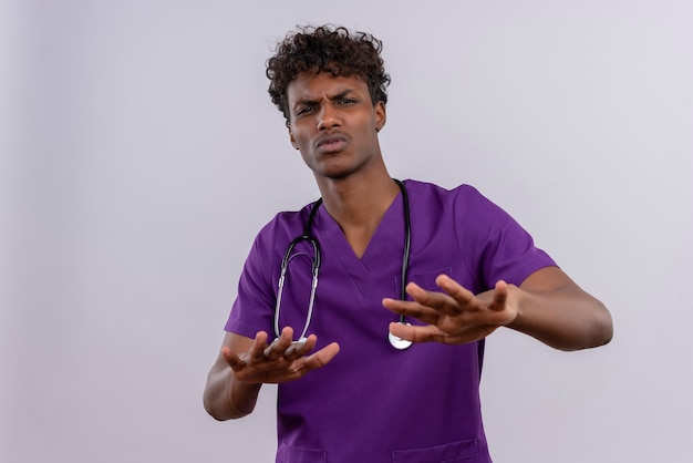 何かを止めようとする聴診器で紫の制服を着た巻き毛の怒っているハンサムな浅黒い医者