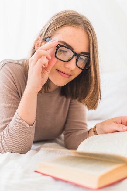 無料写真 魅力的な若い女性が読書の眼鏡を着て