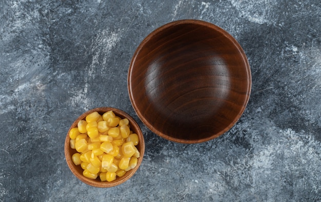 Бесплатное фото Пустая деревянная миска с маленькой миской с семенами попкорна.