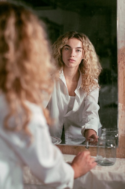 Free photo analog portrait of beautiful woman posing indoors in a mirror