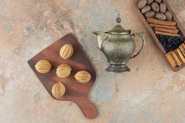 Ancient kettle and sweet round cookies on marble background