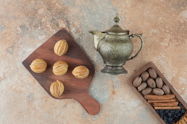 Ancient kettle and sweet round cookies on marble background