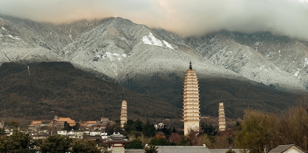 雪をかぶった中国雲南省のCangshan山のある大理旧市街の古代の塔。